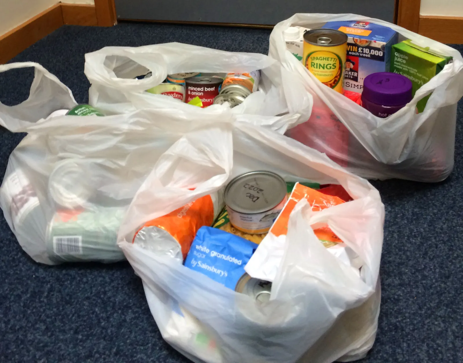 Carrier bags packed with tins, cereal, juice and other food, ready to be delivered